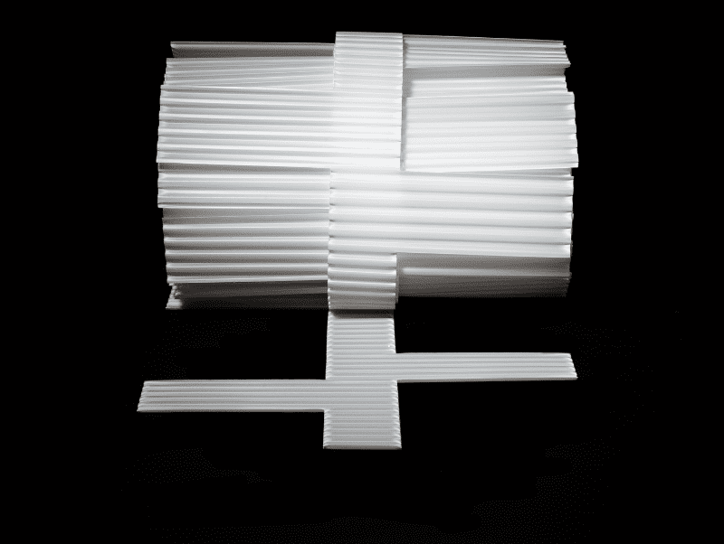 A white plastic Core Cavity Weep for CMU veneers, displayed on a dark background, with a cross-sectional view showing the drainage design.
