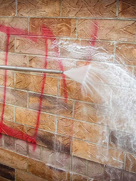 Wall with red spray paint and plastic sheeting, possibly indicating a renovation or cleaning process.