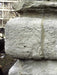 Close-up of a large stone block with visible texture and cracks.