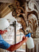 Person using a spray bottle on ornate architectural details