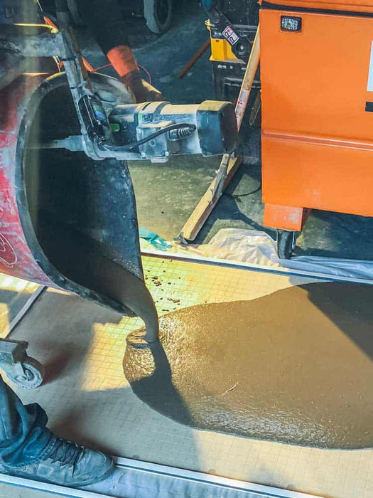 Person using a tool on a pipe with a toolbox in the background