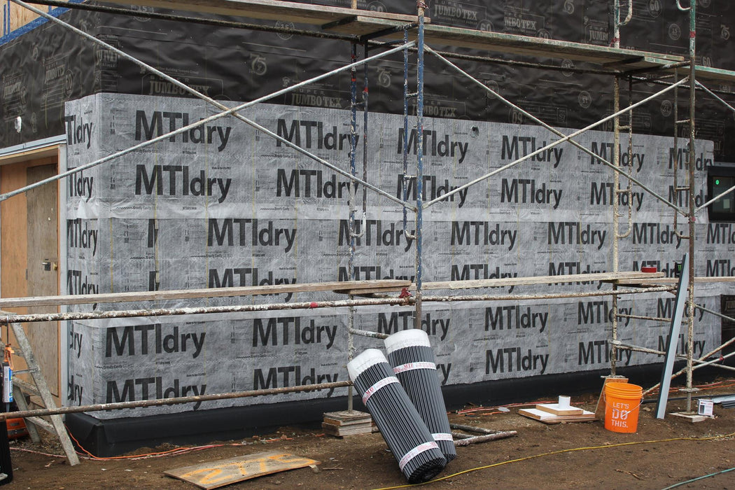Building exterior with MTI dry siding panels and scaffolding.
