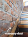 Wooden staircase with masonry dust on a brick wall