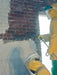 Person in protective gear using a spray gun on a brick wall