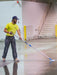 Person cleaning a floor with a mop in an indoor setting