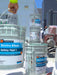 Three buckets labeled 'Enviro Klean Safety Peel 1' on a construction site with workers and buildings in the background.