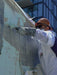 Person in protective gear working on a wall with a tool