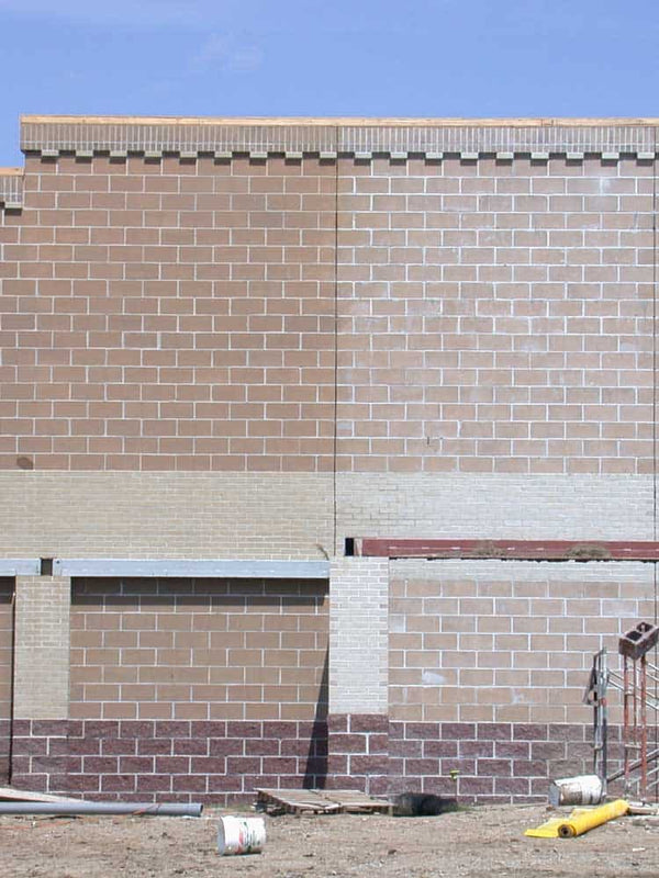 Brick wall with a section of concrete and a blue sky above