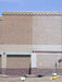 Brick wall with a section of concrete and a blue sky above