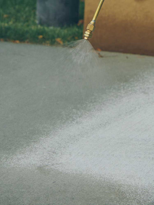 High-pressure water jet cleaning a surface with a focus on the nozzle and water spray.