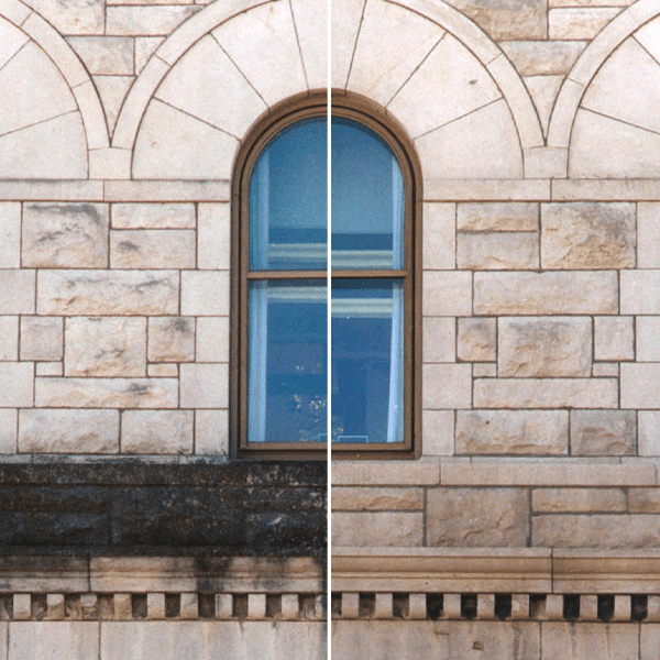 Stone wall with an arched window and blue sky reflection