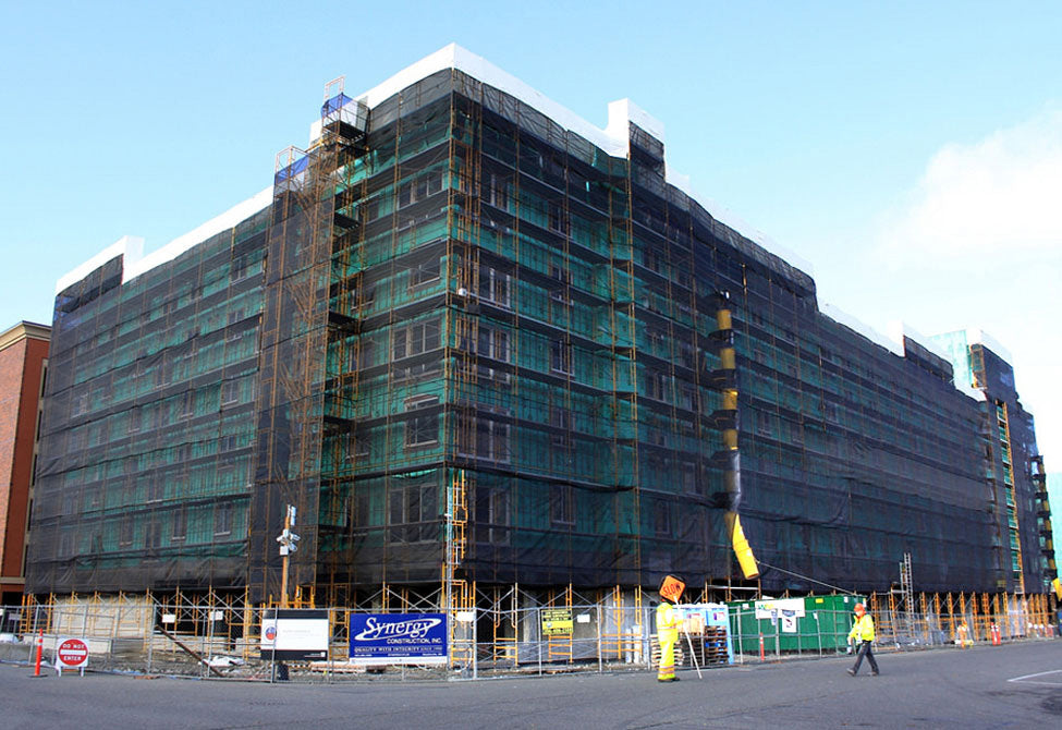 Construction debris netting providing vertical debris protection on scaffolding systems