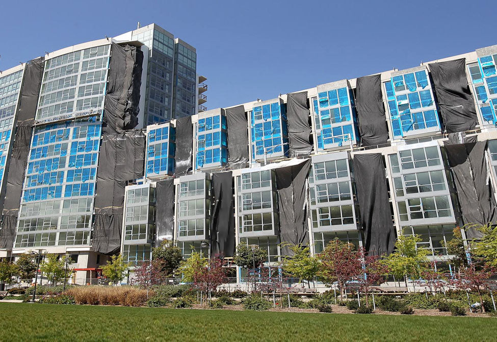 Construction mesh debris tarp providing wind control and shade protection on job sites